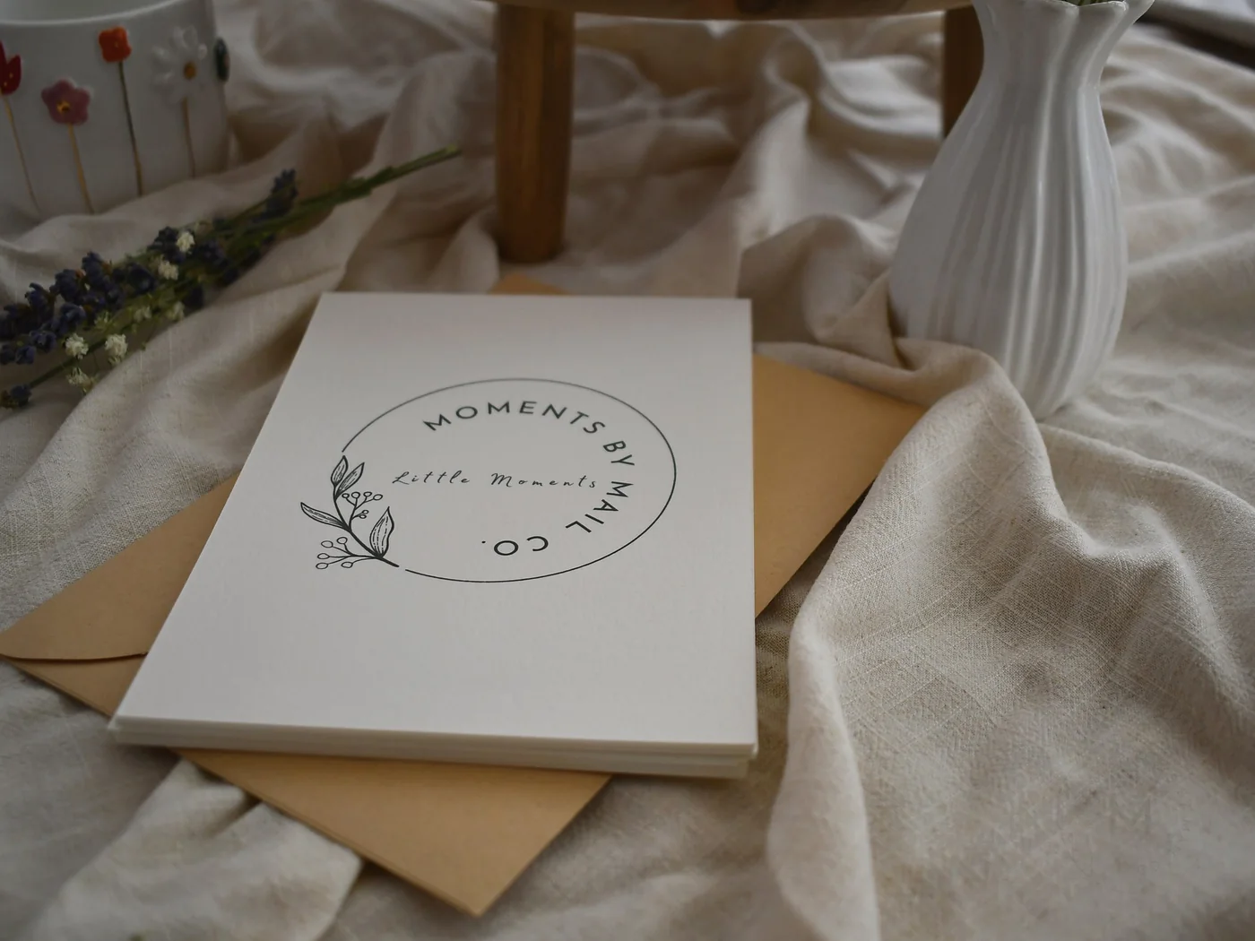 Little Moments cards and envelopes styled with flowers and a vase.
