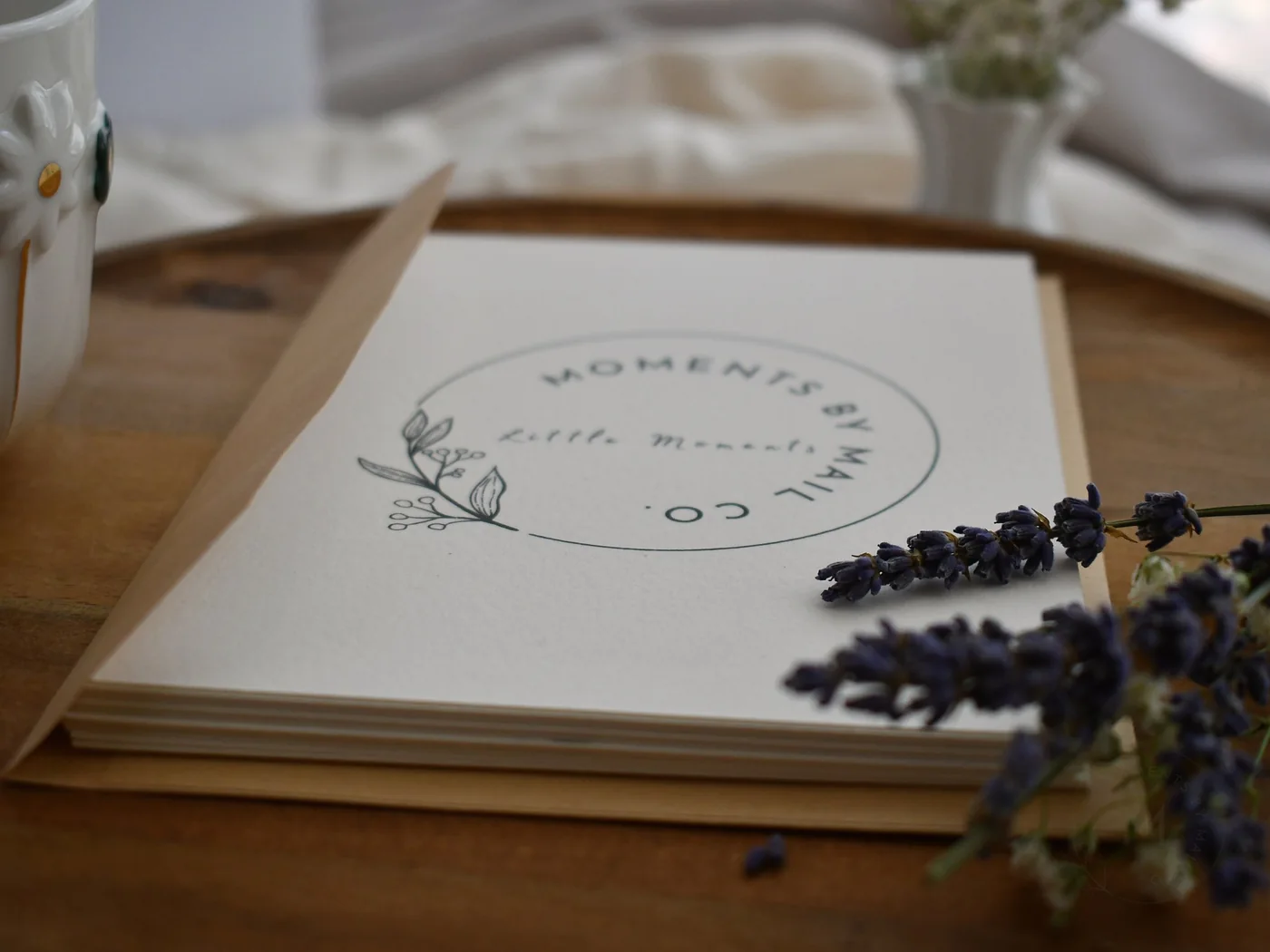 Little Moments card and envelope styled with lavender on a wooden table.