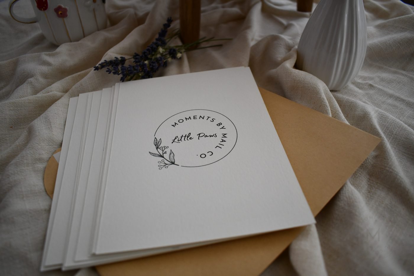 Little Paws keepsake box styled with flowers on a wooden table.