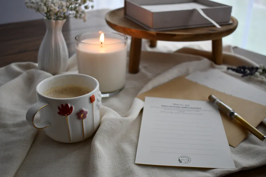 Our Table keepsake prompt card with coffee, candle, flowers, and a memory box.