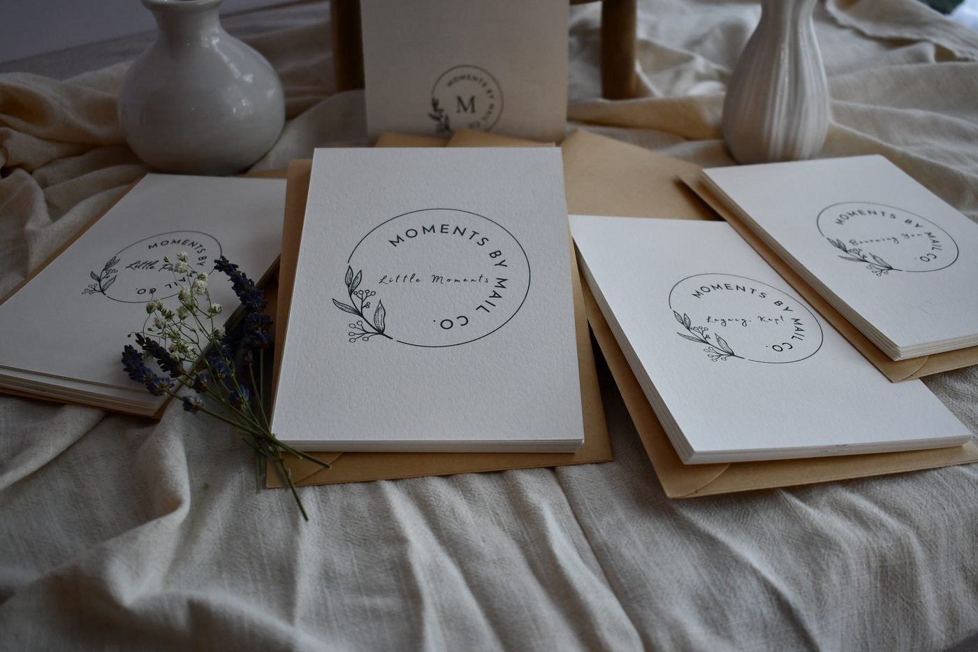 Moments by Mail Co. subscription collections arranged together with lavender and keepsake stationery.