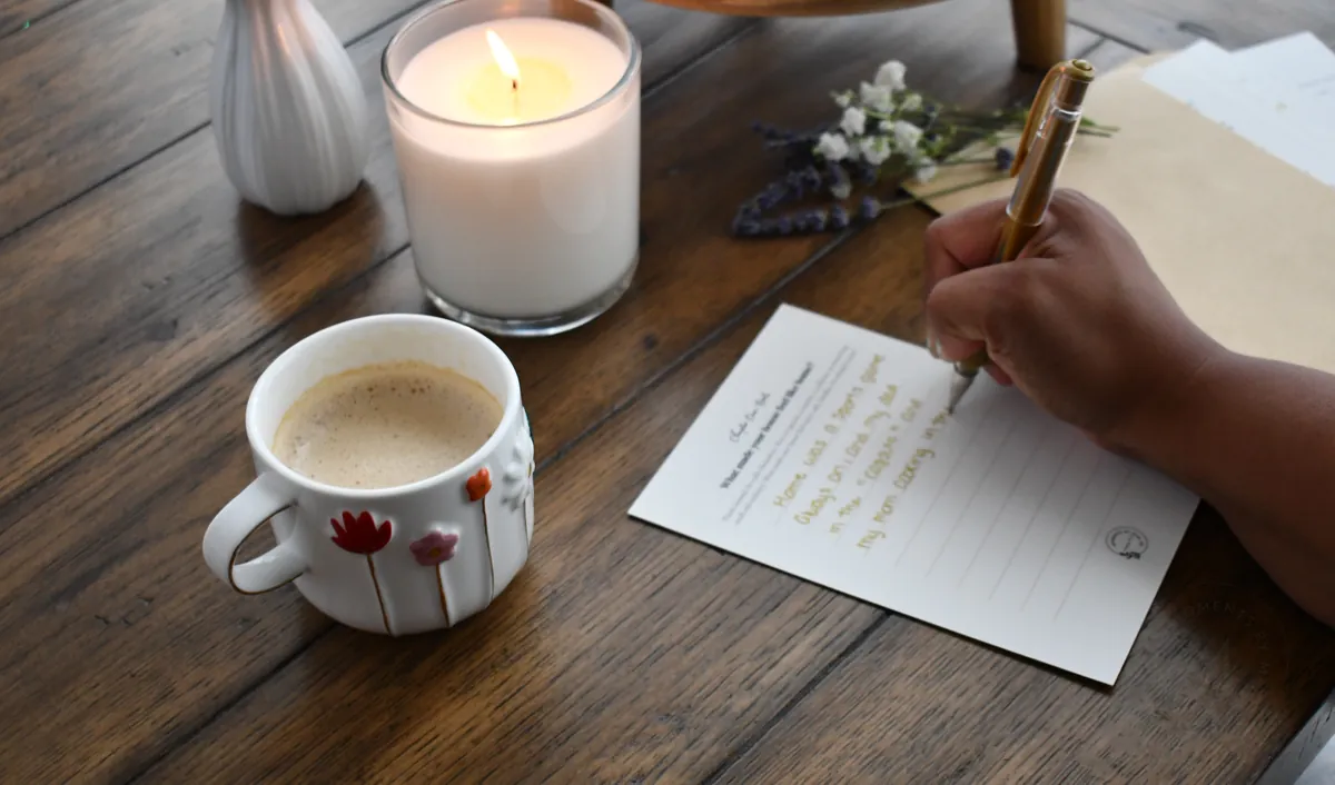 A handwritten memory card being filled out beside coffee and a candle.